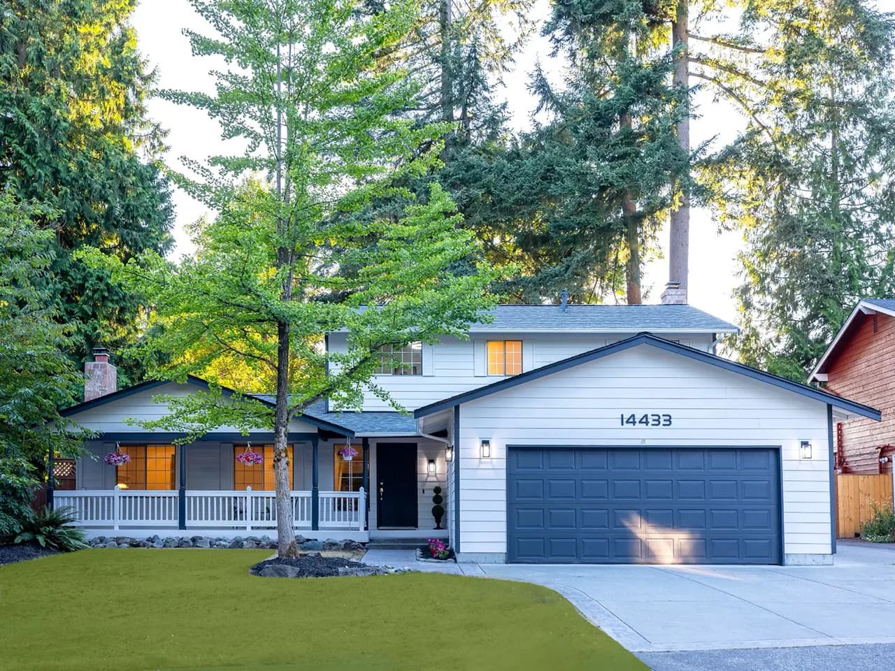 Two-story Eastside home framed by mature evergreen trees.