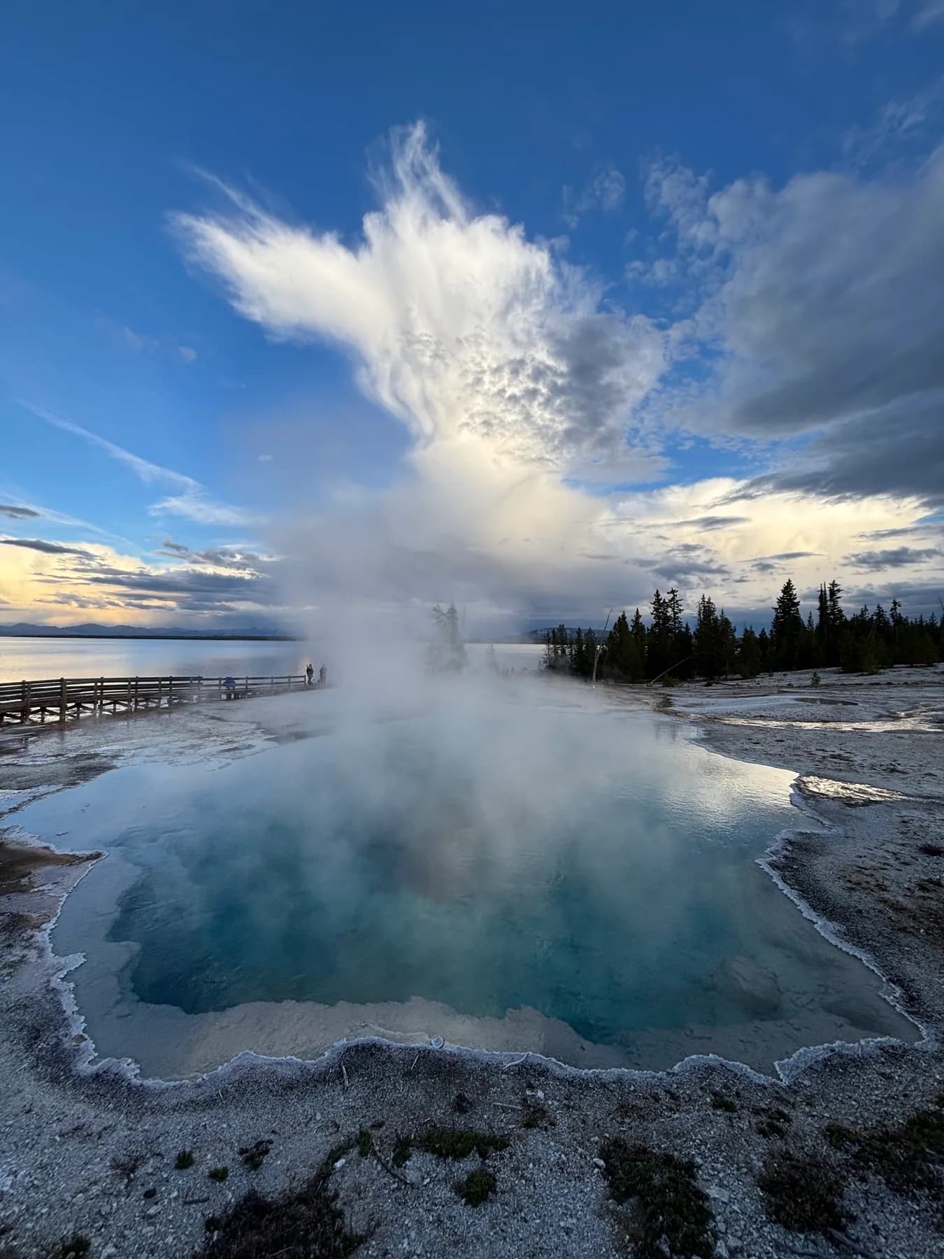 Steam rising from a geothermal pool beneath an evening sky.