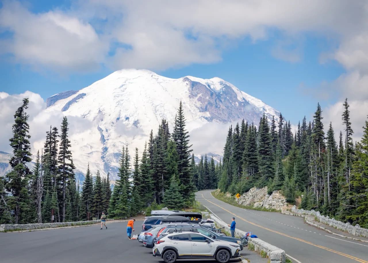 Mount Rainier above a forest road and overlook.