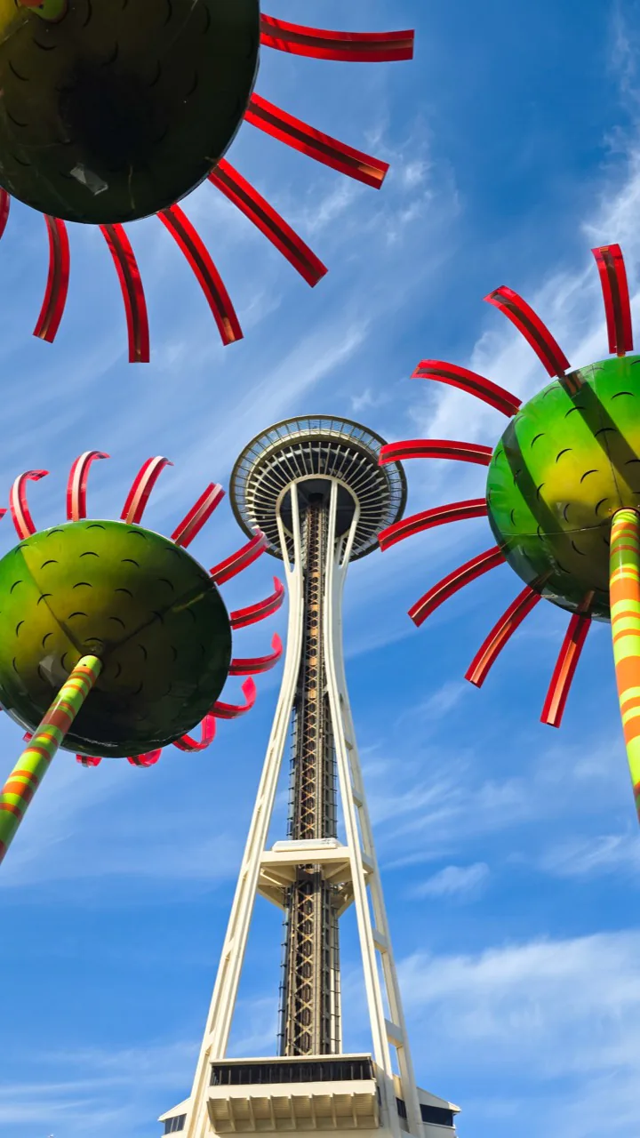 Space Needle viewed through colorful Seattle Center sculptures.