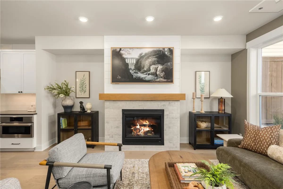 Homesite 3 living room with a central fireplace and open connection to the kitchen.