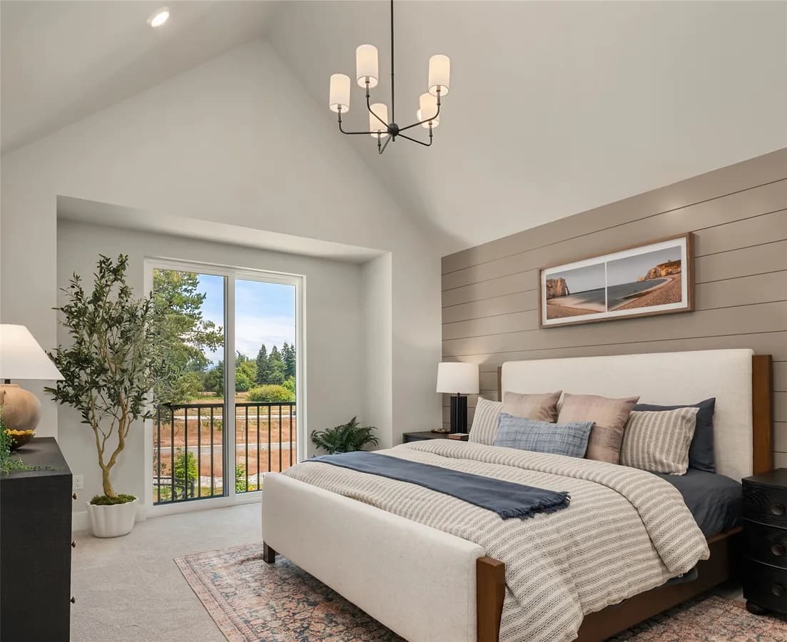 Homesite 33 primary bedroom with a vaulted ceiling and view toward the community grounds.