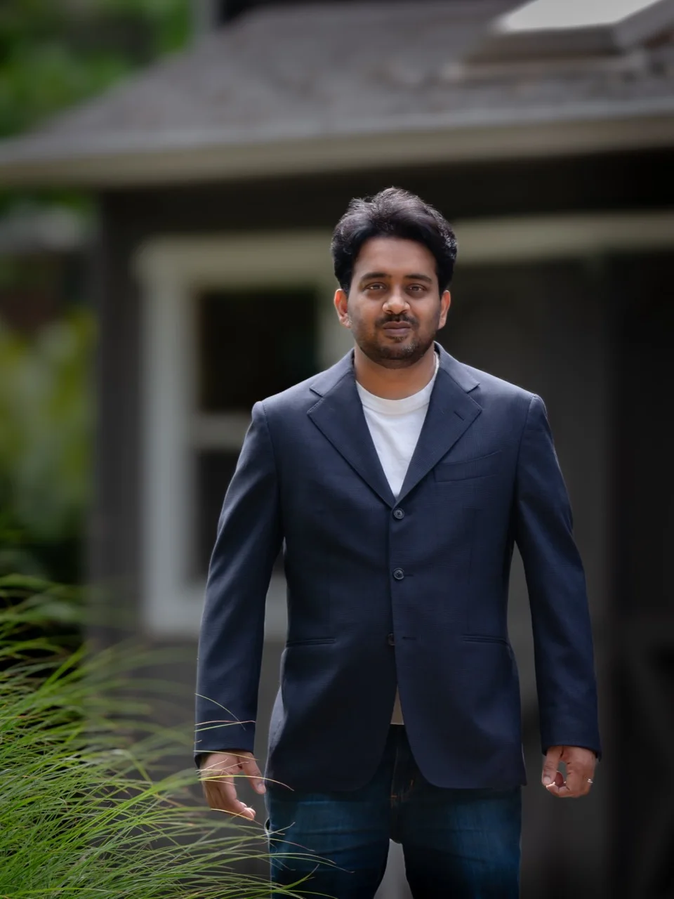 Aditya Kasturi standing outside in a navy blazer.